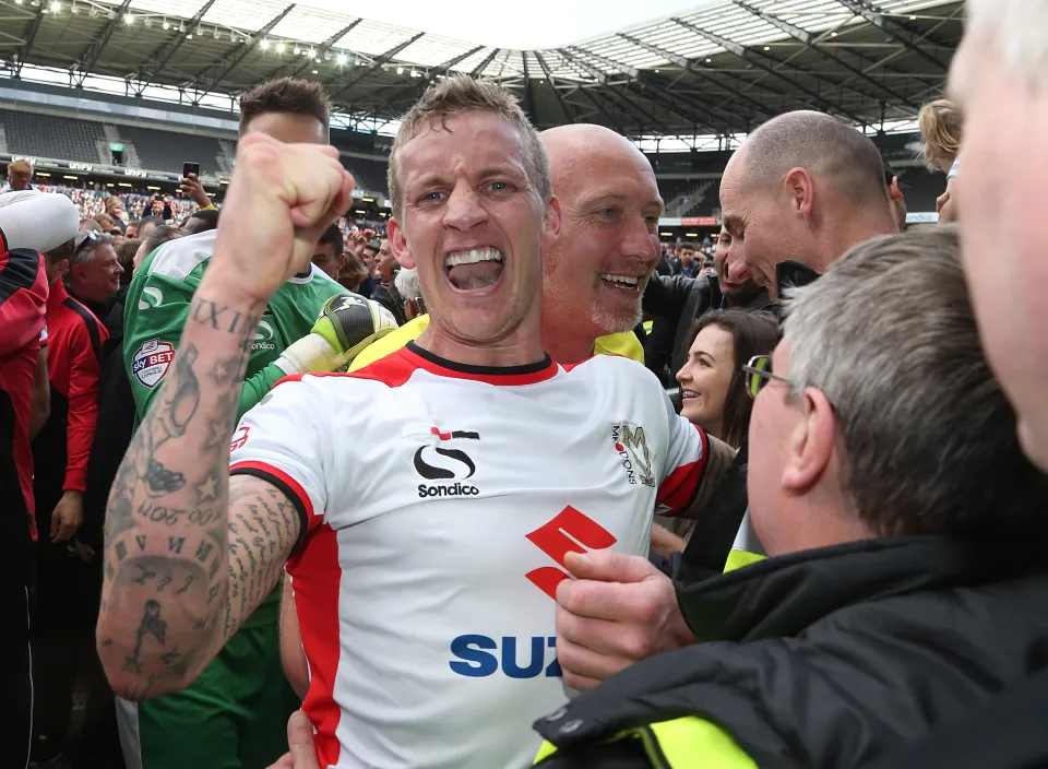 كارل بيكر من MK Dons يحتفل بالترقية إلى البطولة.