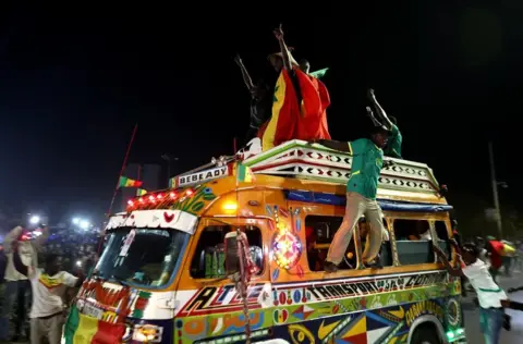 رويترز مشجعون يتكئون من نوافذ سيارة أجرة صغيرة احتفالا.