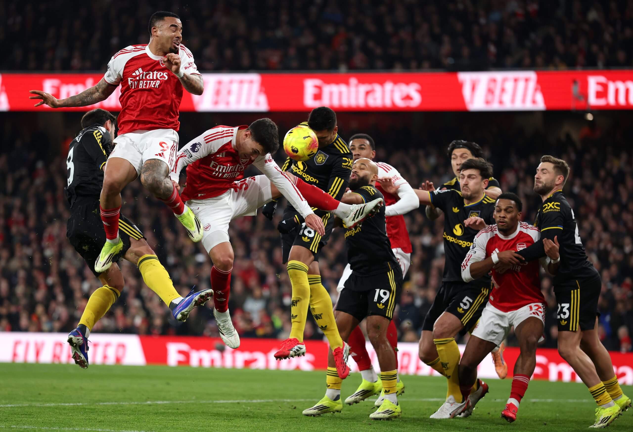 مارتن زوبيميندي ينحني ليسدد الكرة برأسه وسط مجموعة من لاعبي أرسنال ومانشستر يونايتد